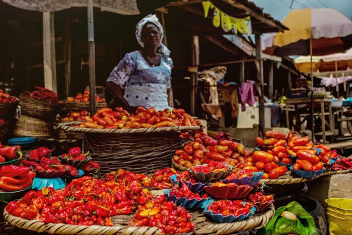 A woman selling pepper and tomatoes