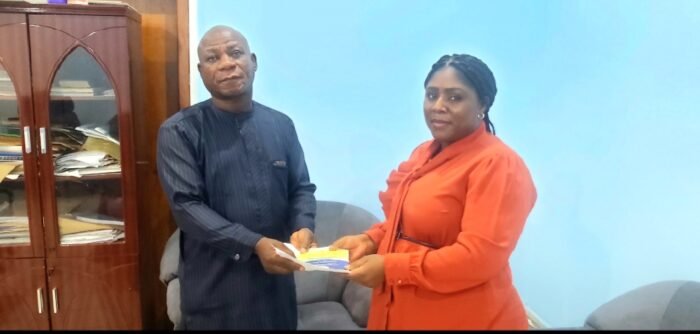 ACTU desk officer, Mrs Victoria Giwa presenting her letter of introduction to Mr Muftau Ojo, representative of the NAN Managing Director