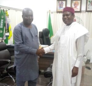 Mr Casmir Irekamba, President, Unemployed Youth Association of Nigeria (UYAN), in a handshake with the Director-General of National Directorate of Employment (NDE) Malam Abubakar Nuhu during a partnership visit in Abuja