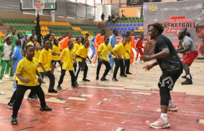 Former Nigeria Basketball International, Sam Oguche (right), drilling the students during the opening of Abuja Metro High School Basketball League at the Mo Sports Arena in Abuja