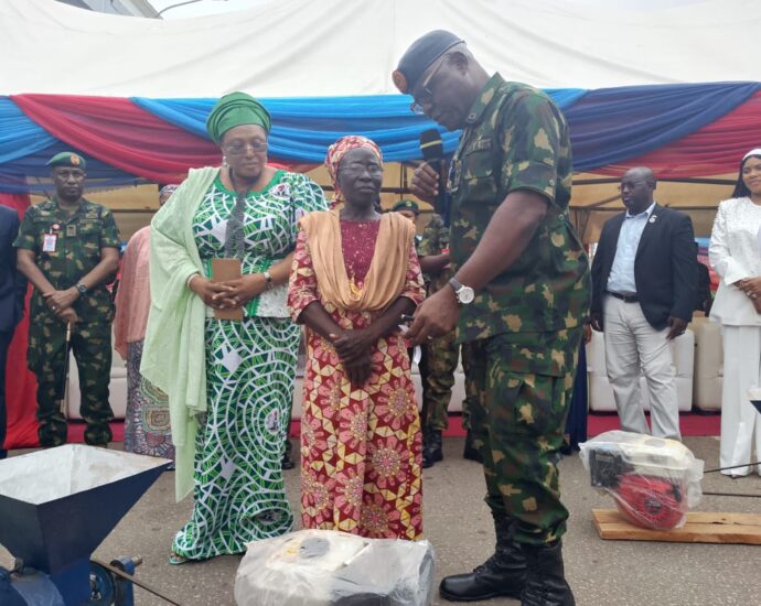 Nigerian Legion National Chairman, Ms Grace Henry (1st Left) with a beneficiary  and others at the empowerment programme and induction of ex-servicemen into the Institute of Disaster Management and Safety Sciences (IDMSS) on Monday in Abuja 