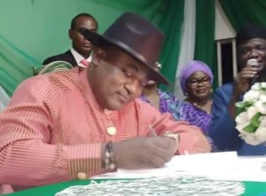 Newly inaugurated chairman, Bwari Area Council, Mr Joshua Ishaku, signing the documents.