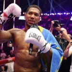Anthony Joshua celebrating victory after knocking out Kristian Prenga in a heavyweight bout