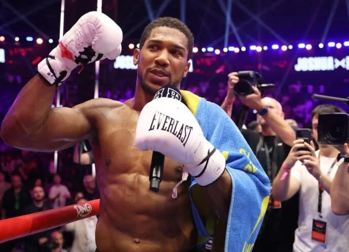 Anthony Joshua celebrating victory after knocking out Kristian Prenga in a heavyweight bout
