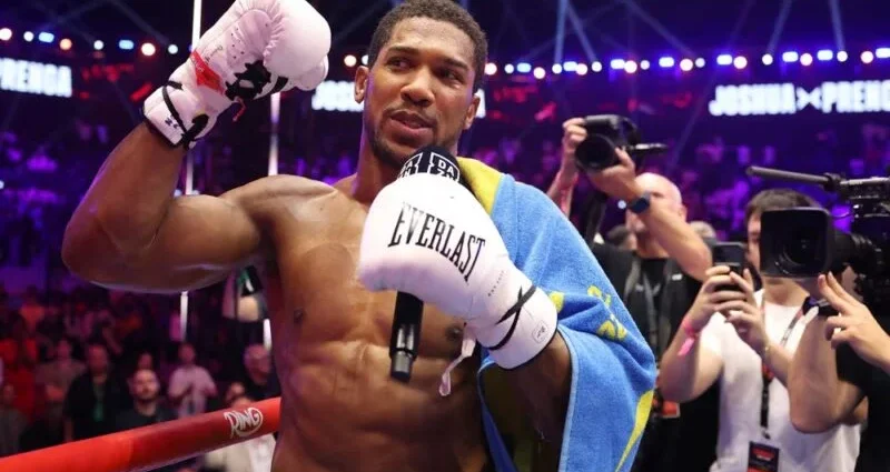 Anthony Joshua celebrating victory after knocking out Kristian Prenga in a heavyweight bout