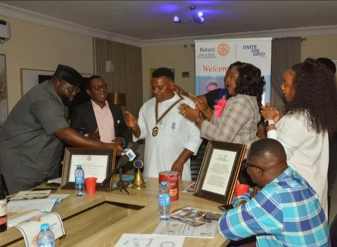 Outgoing president of Rotary Club of Abuja, The Ambassadors, Nelly Williams, handing over the symbol of leadership to Prince Herberts, at a ceremony in Abuja.(PhotoCredit:NAN)