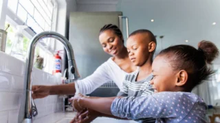 Children engaging in hand washing with their mother